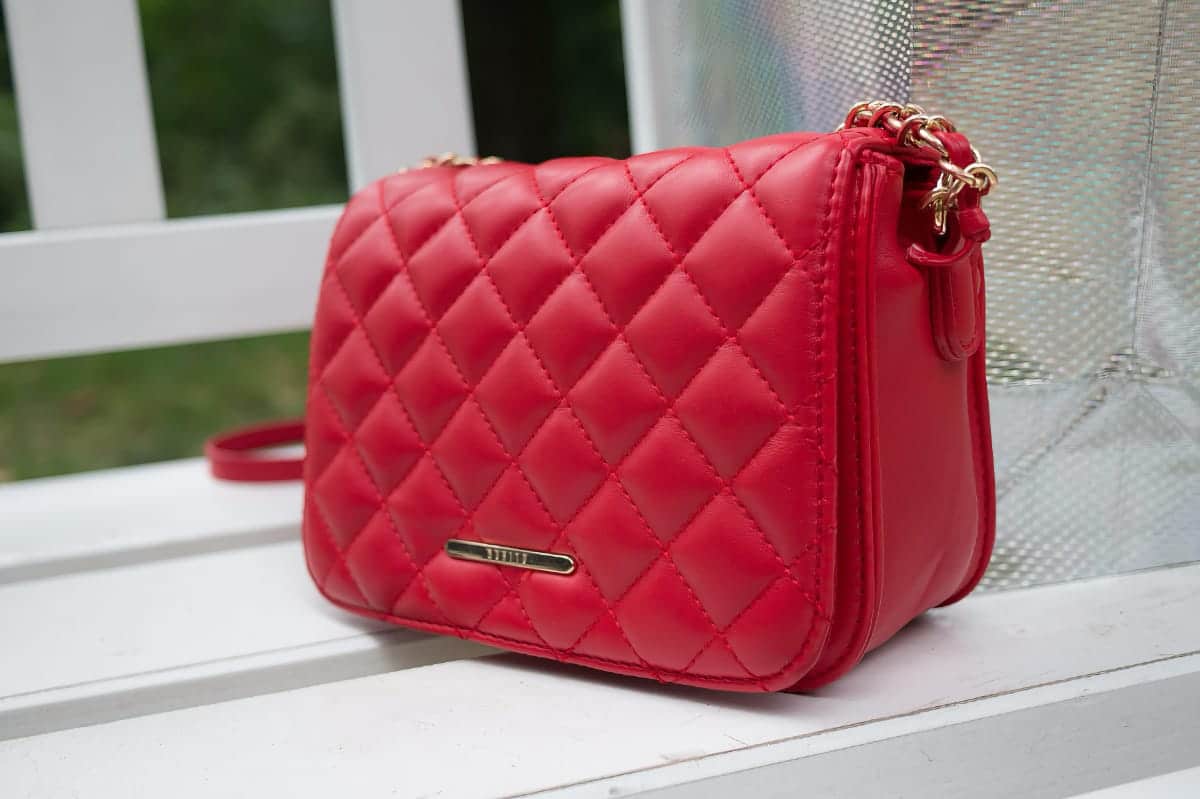 Sac à main en cuir rouge matelassé posé sur une table