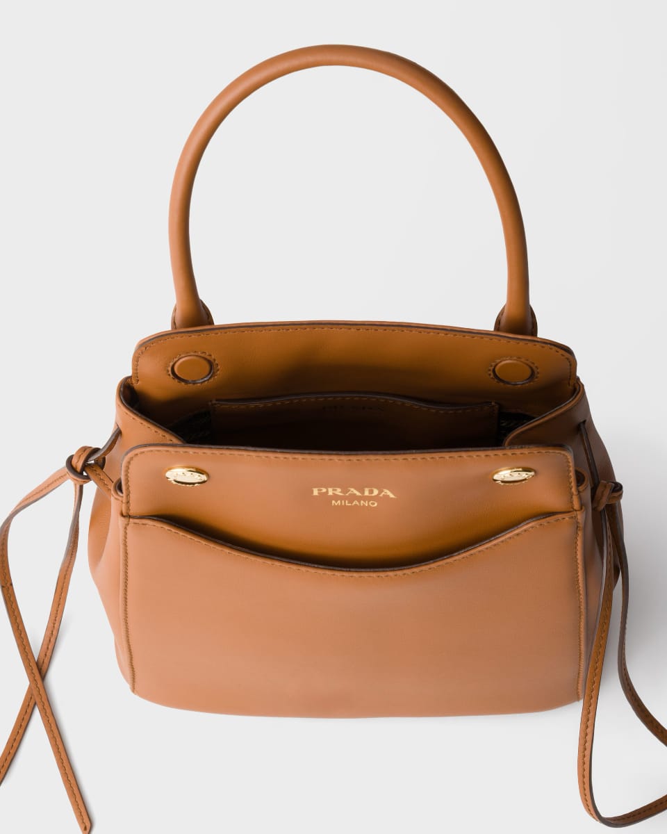 Intérieur du sac Prada Carry ouvert, avec liens coulissants et logo Prada Milano